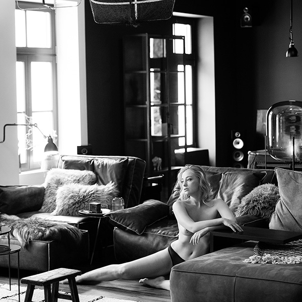 Artistic nude photography of a woman in a modern, opulent room with minimalist design and elegant lighting.