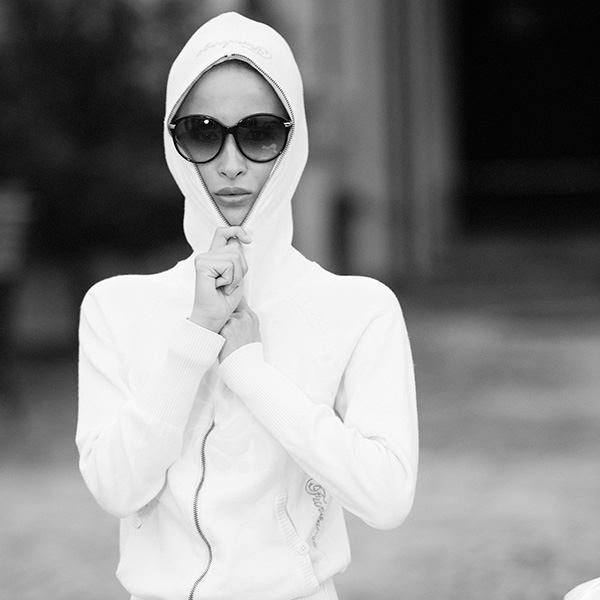 Erotische Aktfotografie einer Frau auf einer Vespa mit weißer Kapuzenjacke und Sonnenbrille