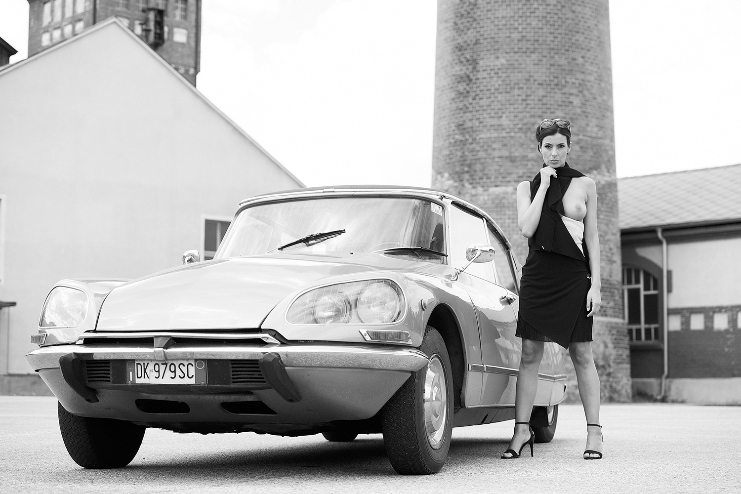 Moderne Kunst in Schwarz-Weiß – stilvolle Aktfotografie mit klassischem Citroën DS vor urbaner Kulisse