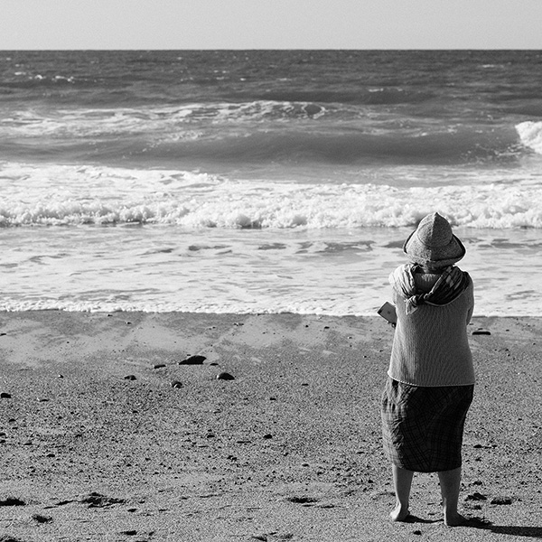 Frau am Strand mit Blick aufs Meer, künstlerische Streetphotography