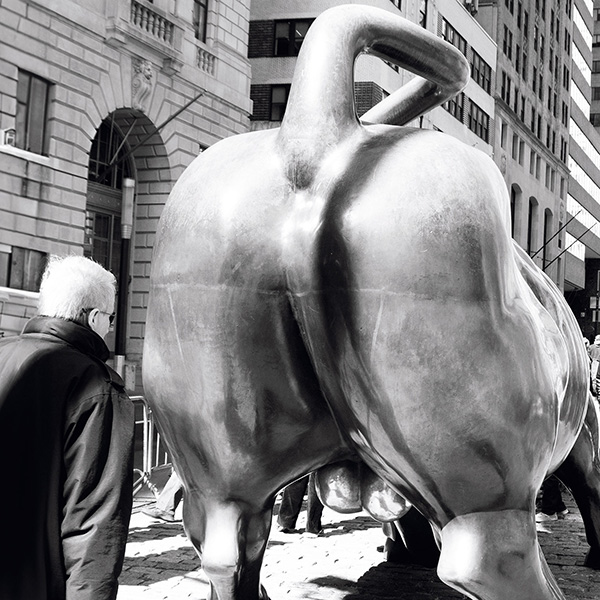 Künstlerische Streetphotography eines Mannes vor dem Charging Bull in New York.