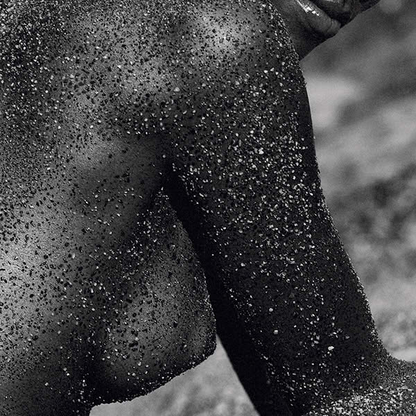 GRAIN – skin covered in black sand, back view on the beach – Nude Photos Edition FIVE WORKS
